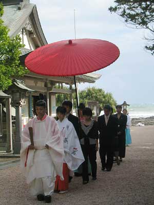 本殿まで進んでます。傘が真っ赤で派手です。地面が砂&貝殻なので,ヒールが埋まります。天気はいまいち。